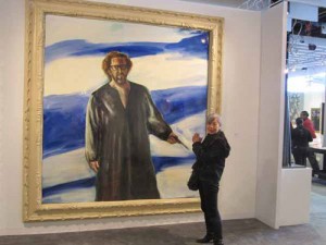 Art writer Lilly Wei strikes a supplicating pose in the presence of Julian Schnabel’s massive 2007 self-portrait at Galerie Forsblom, Helsinki.