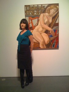 Candace Mills posing with a work by Philip Pearlstein