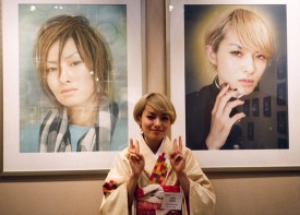 Ayano Sudo standing before two works from her series, thats cause that guy isn't human but? some kind of godish japanese hottie from another world  2010. Inkjet prints on Arche paper, 70 cm x 100 cm each. Photo: Robin Siegel