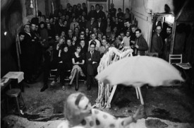 Pat Oldenburg (on ladder), Henry Edelheit (center, in glasses), Fred McDarrah (right, with camera) in Claes Oldenburg’s Circus: Ironworks/Fotodeath at the Reuben Gallery, February 1961. © Robert R. McElroy/Licensed by VAGA, New York, New York