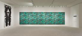 Installation shot of the exhibition under review with, center, Andy Warhol, Camouflage, 1986. Synthetic polymer paint and silk screen on canvas, 118 by 420 inches. Courtesy of The Brant Foundation, Greenwich, CT.