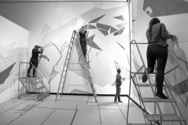 Dannielle Tegeder (second from left) and assistants in the process of creating the site-specific wall drawing Ondam, at the Wellin Museum of Art, May 2013