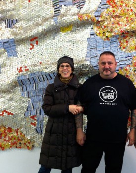 Leslie Wayne and Claude Simard in front of a work by El Anatsui, 2012. Courtesy of Jack Shainman Gallery