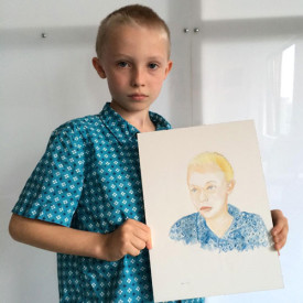 Walker Ginzel (son on Sarah Walker and Andrew Ginzel) holding "Watercolor Portrait a Day" #180 by Brenda Zlamany. Photo: Brenda Zlamany