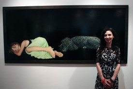 Brenda Zlamany pictured with her Portrait #120 showing the author as a young girl with the family dog, Sallie. Courtesy Hamptons Art Hub, 2013