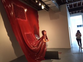 Silas Riener performing a dance integrated with the sculpture of Martha Friedman, Pore, 2015. At Locust Projects.